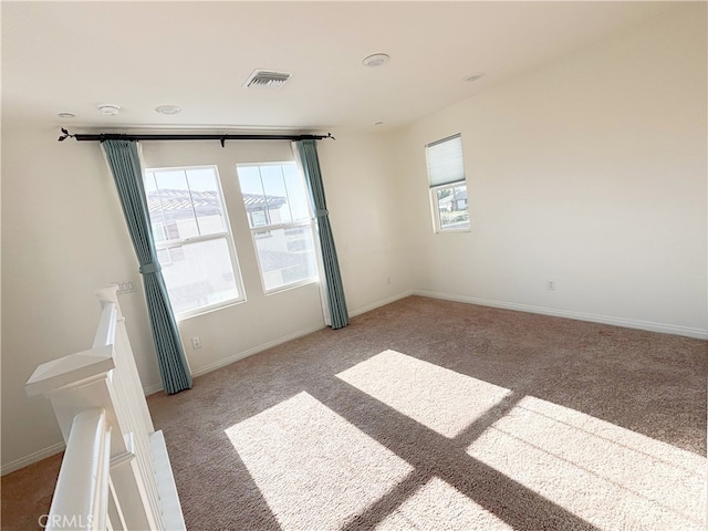 unfurnished room with light colored carpet, baseboards, and visible vents