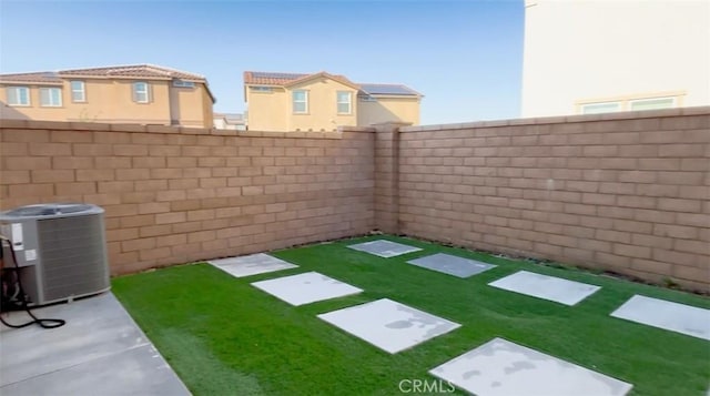 view of yard with central AC unit and a fenced backyard