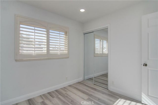 unfurnished bedroom with light hardwood / wood-style floors and a closet