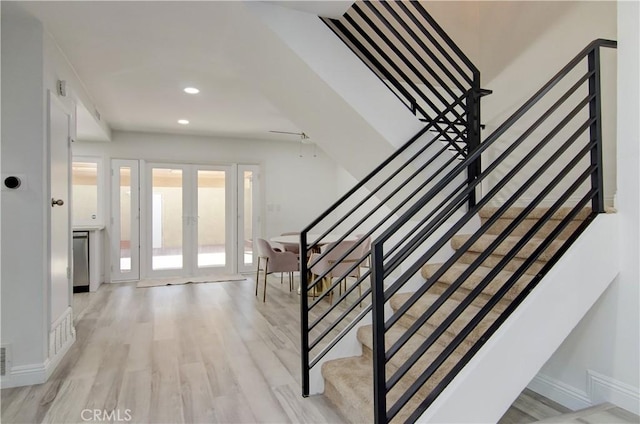 staircase with hardwood / wood-style flooring and french doors