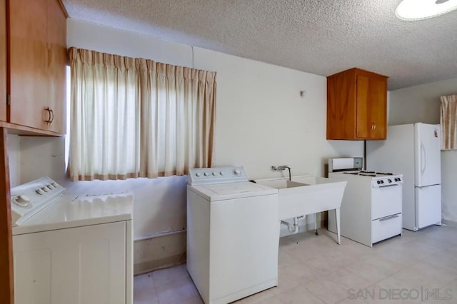 laundry room featuring separate washer and dryer and a textured ceiling