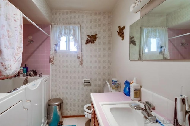 bathroom featuring tiled shower, tile patterned floors, toilet, and vanity