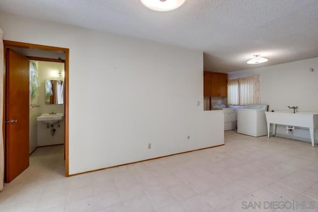 interior space with washing machine and dryer, sink, and a textured ceiling