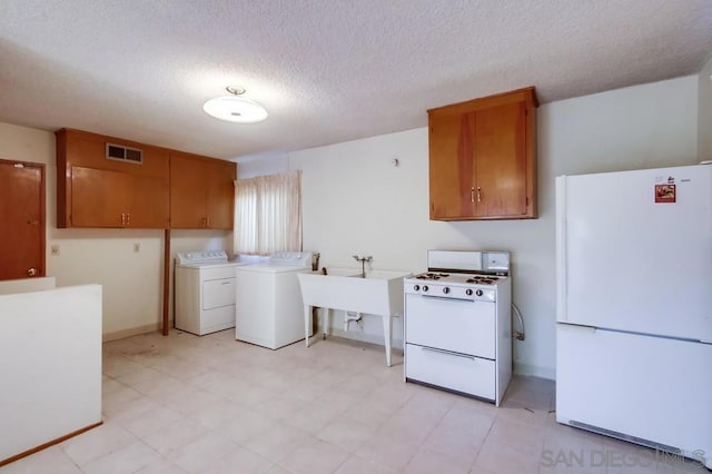 laundry area featuring cabinets, independent washer and dryer, sink, and a textured ceiling