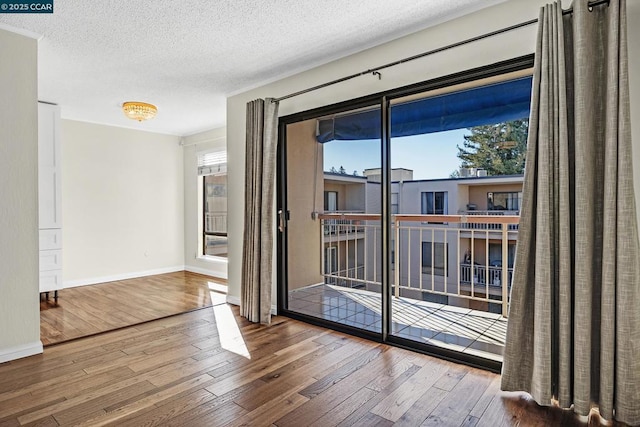 doorway to outside featuring wood-type flooring and a textured ceiling