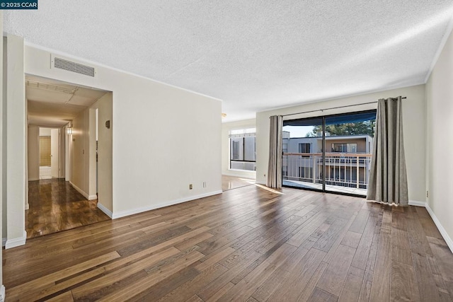 spare room with dark hardwood / wood-style flooring and a textured ceiling