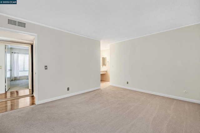 carpeted spare room with crown molding