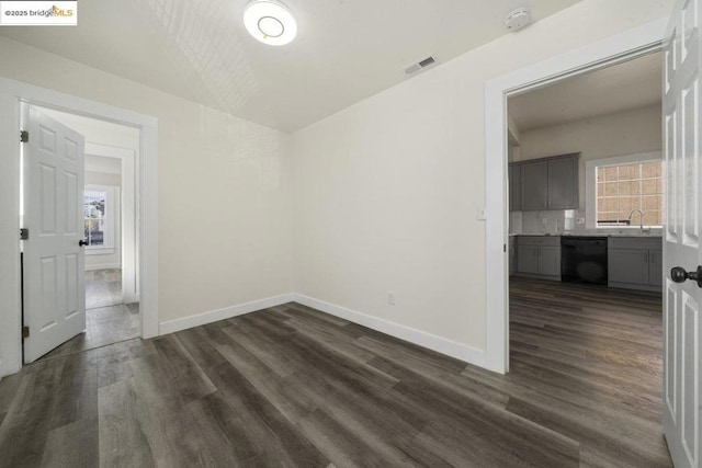 unfurnished room featuring sink and dark hardwood / wood-style floors