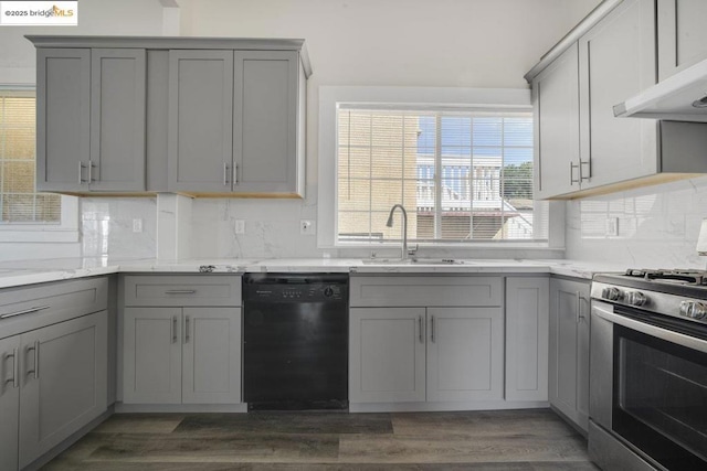 kitchen featuring dishwasher, sink, gray cabinetry, gas stove, and light stone countertops