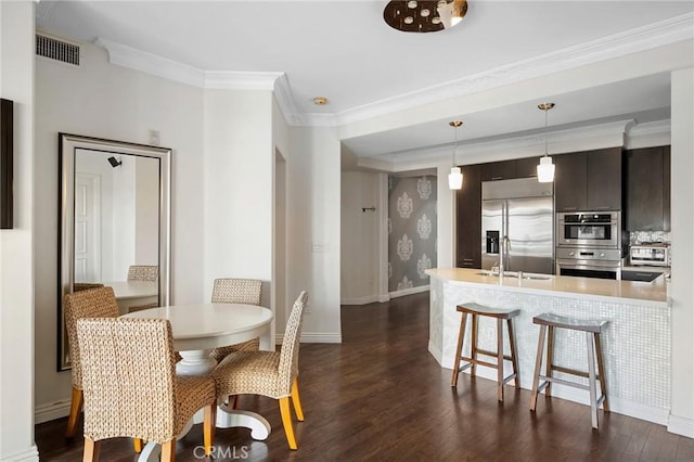 dining room featuring ornamental molding, sink, and dark hardwood / wood-style floors