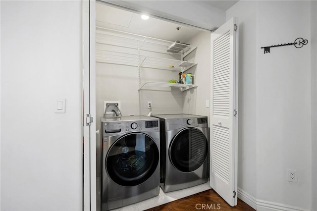 clothes washing area featuring separate washer and dryer and dark hardwood / wood-style flooring