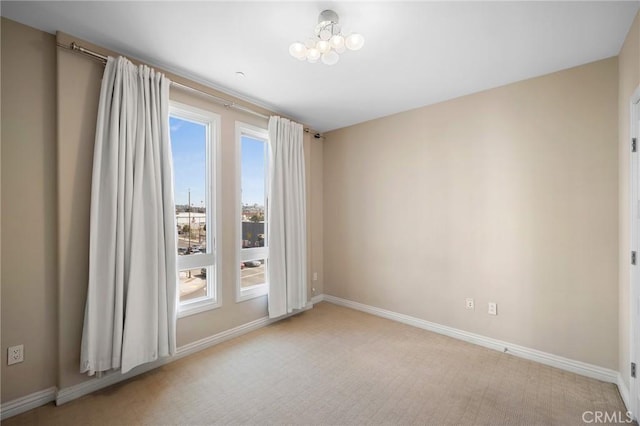 unfurnished room with light carpet and a notable chandelier