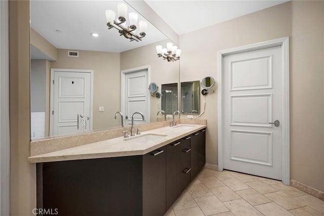 bathroom with tile patterned flooring, vanity, and a chandelier