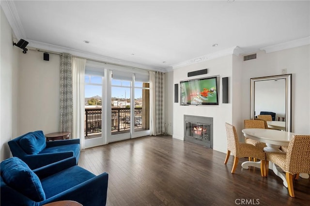 living area with ornamental molding and dark hardwood / wood-style flooring