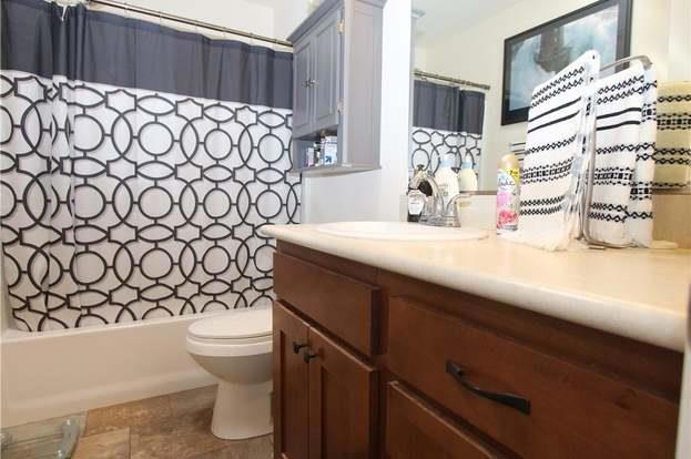 full bathroom featuring vanity, shower / tub combo, and toilet