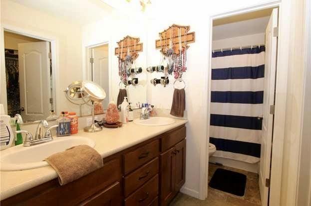 bathroom with a shower with curtain, vanity, toilet, and tile patterned flooring