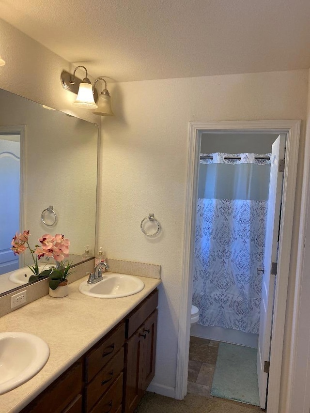 bathroom with vanity, toilet, and curtained shower