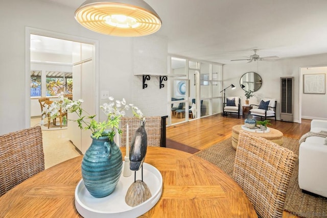 dining area featuring wood-type flooring and ceiling fan