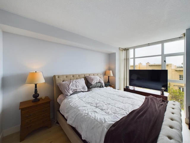 bedroom featuring hardwood / wood-style flooring and expansive windows