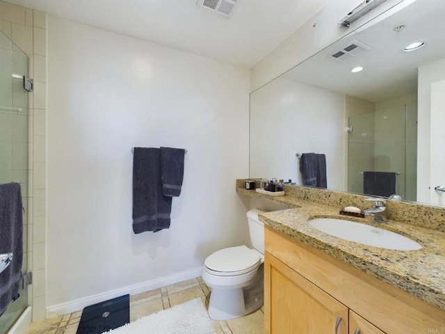 bathroom with tile patterned flooring, vanity, a shower with shower door, and toilet