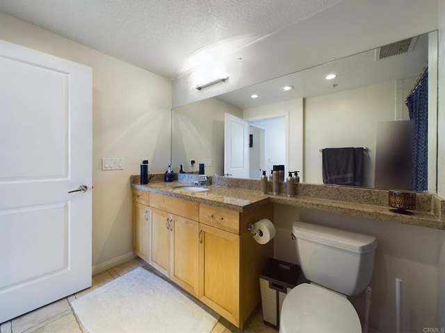 bathroom with vanity, tile patterned floors, toilet, and a textured ceiling