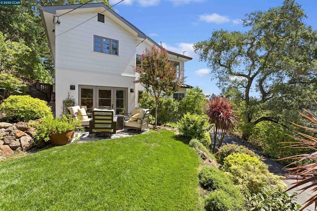 rear view of house with an outdoor living space and a lawn