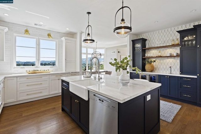 kitchen with pendant lighting, sink, dishwasher, white cabinetry, and an island with sink