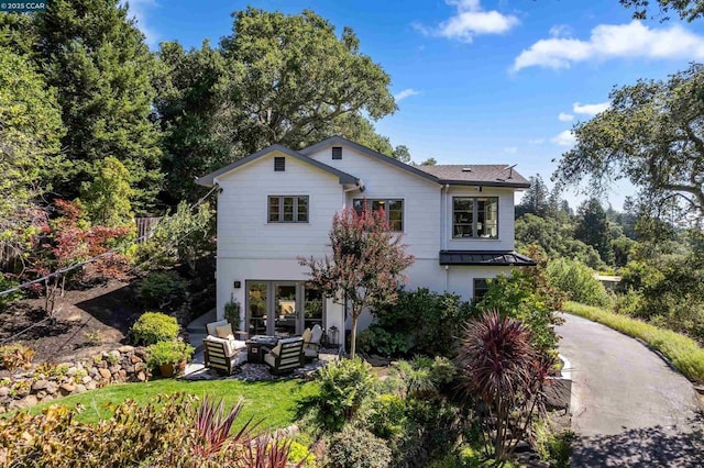 rear view of house featuring a yard and outdoor lounge area