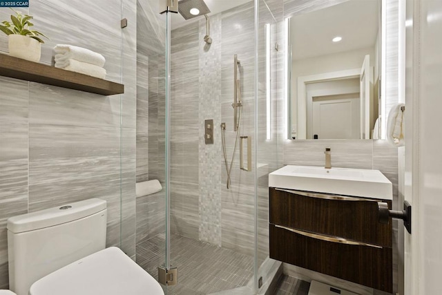 bathroom with tile walls, vanity, toilet, and walk in shower