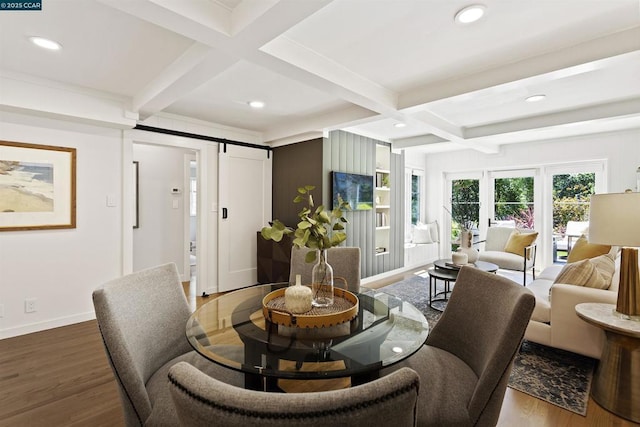 living room featuring coffered ceiling, hardwood / wood-style floors, a barn door, and beamed ceiling