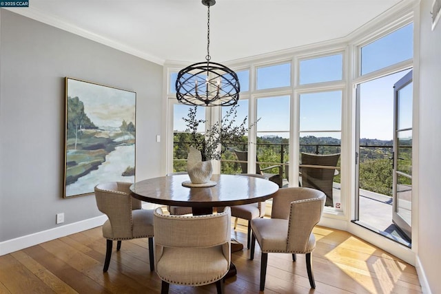 dining space featuring crown molding, a chandelier, and hardwood / wood-style flooring