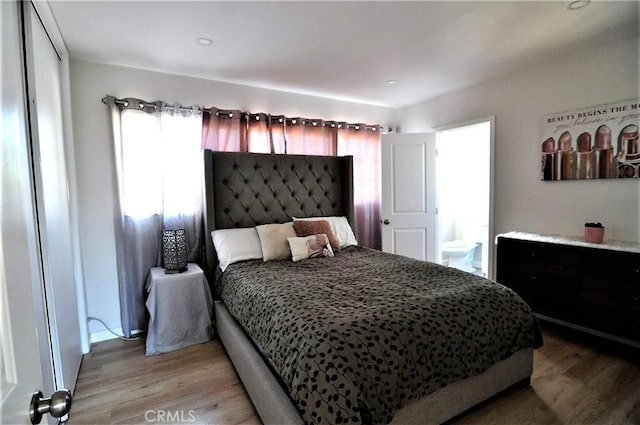 bedroom featuring light hardwood / wood-style flooring and ensuite bathroom