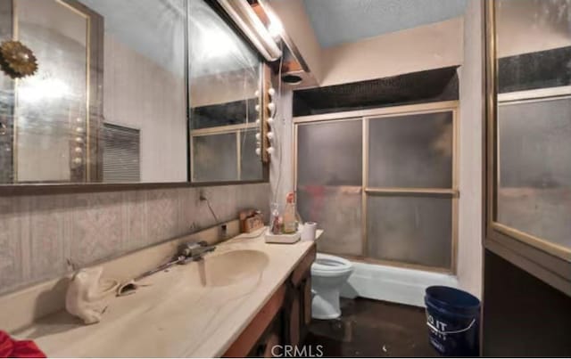 bathroom featuring wooden walls, vanity, and toilet