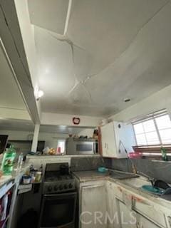 kitchen featuring white cabinetry and black range