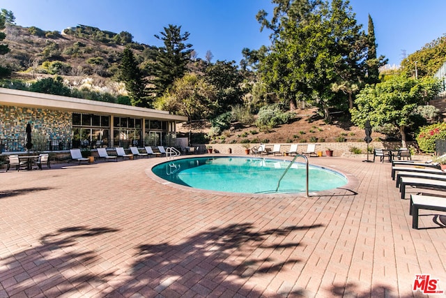 view of pool with a mountain view and a patio area