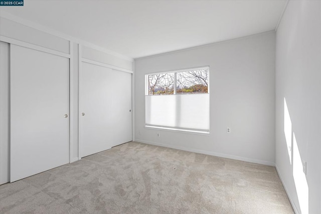 unfurnished bedroom featuring crown molding and light colored carpet