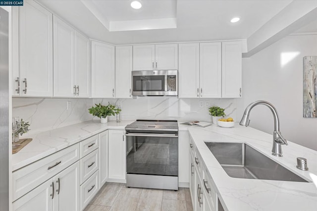 kitchen featuring light stone countertops, appliances with stainless steel finishes, and sink