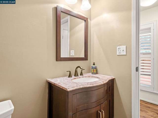 bathroom with vanity, toilet, and hardwood / wood-style floors