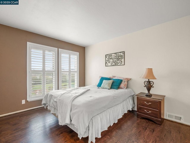 bedroom with dark hardwood / wood-style flooring