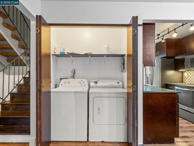 clothes washing area featuring hardwood / wood-style floors and washing machine and dryer