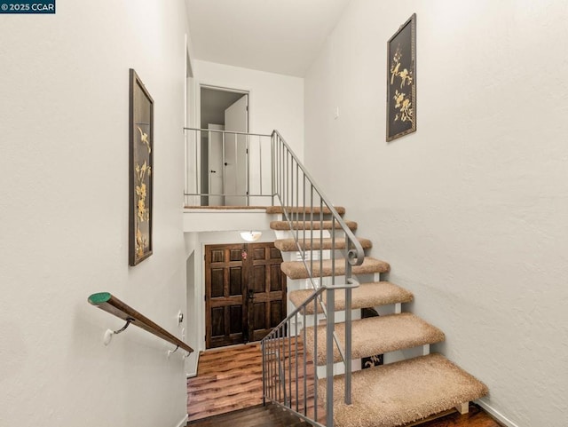 staircase with wood-type flooring