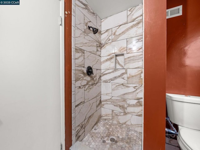 bathroom featuring toilet and tiled shower