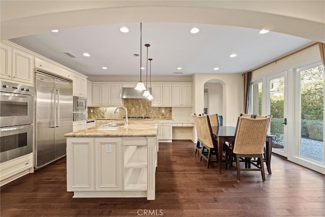 37 Triple Leaf, Irvine, CA 92620 - kitchen featuring built in appliances, a sink, a warming drawer, dark wood-type flooring, and arched walkways