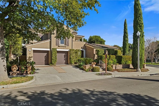 mediterranean / spanish-style house featuring concrete driveway and stucco siding