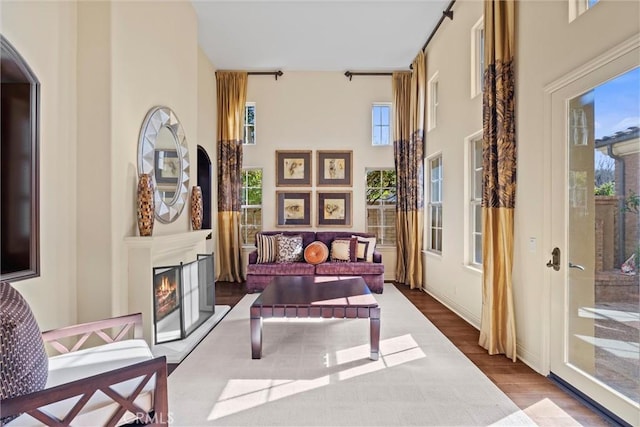 37 Triple Leaf, Irvine, CA 92620 - sitting room featuring wood finished floors, plenty of natural light, a towering ceiling, a warm lit fireplace, and arched walkways