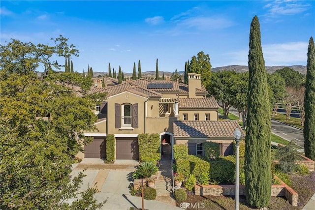 37 Triple Leaf, Irvine, CA 92620 - mediterranean / spanish home featuring concrete driveway, solar panels, an attached garage, stucco siding, and a mountain view