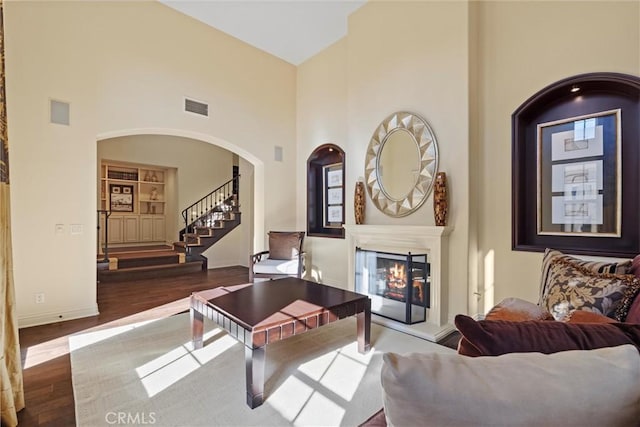 37 Triple Leaf, Irvine, CA 92620 - living area with a high ceiling, wood finished floors, a glass covered fireplace, stairway, and arched walkways