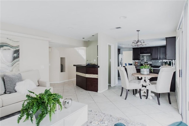 tiled dining space featuring an inviting chandelier