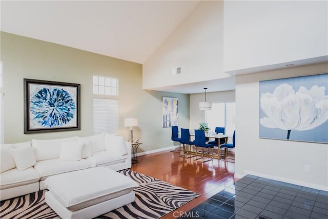 living room with high vaulted ceiling and dark hardwood / wood-style floors