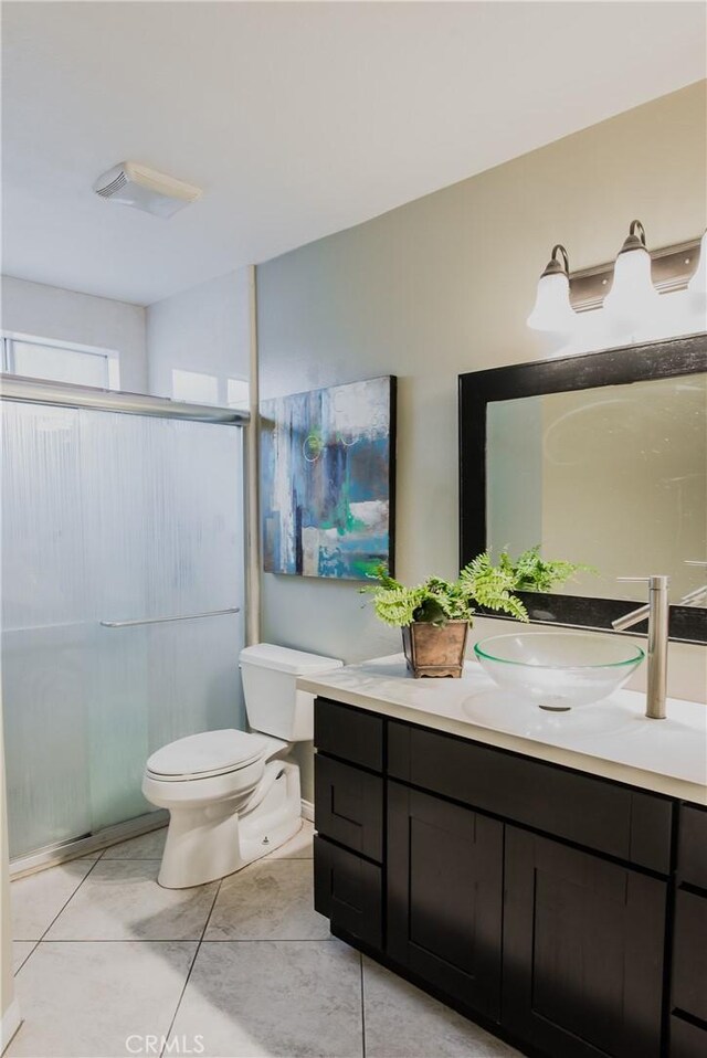 bathroom with vanity, a shower with door, and toilet